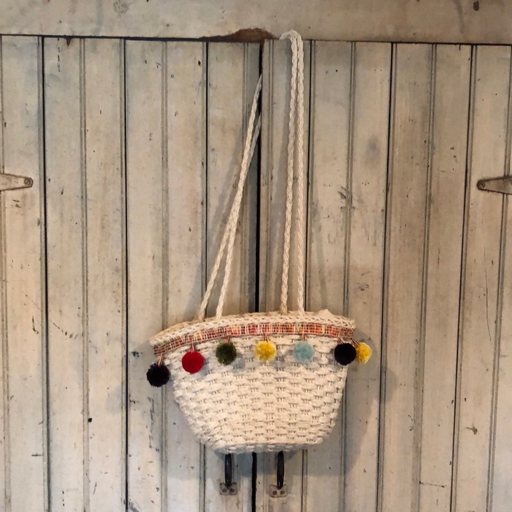 Like new straw hand bag with Pom poms.